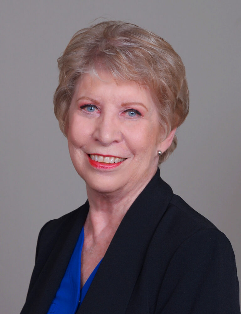 Linda Ellis is a white woman with short, light-colored hair, wearing a black blazer.